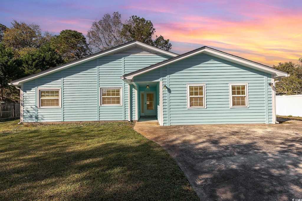 single story home with a lawn