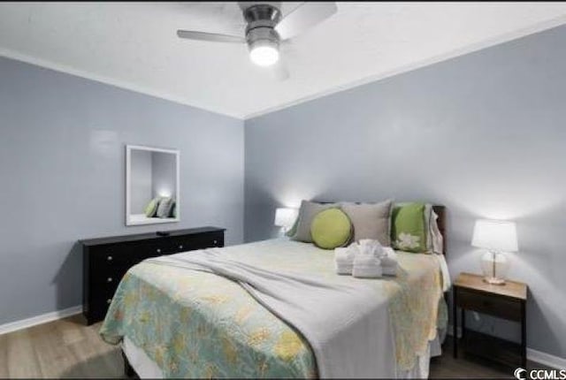 bedroom with ornamental molding, dark hardwood / wood-style floors, and ceiling fan