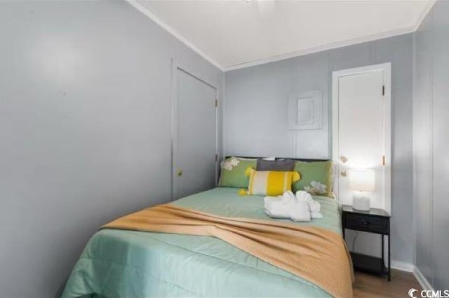 bedroom with hardwood / wood-style flooring and ornamental molding