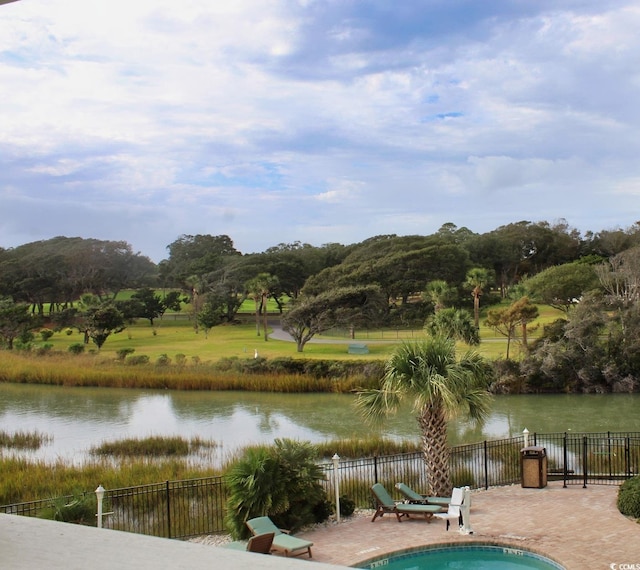 view of swimming pool with a water view, a patio area, and a lawn