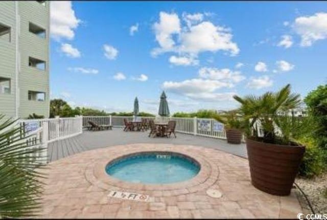 view of swimming pool with a hot tub and a patio area