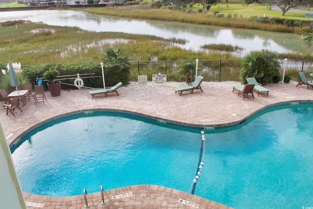 view of pool with a water view and a patio area