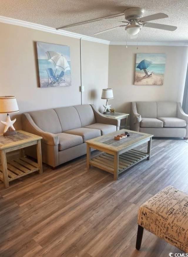 living room featuring wood-type flooring, a textured ceiling, ceiling fan, and ornamental molding