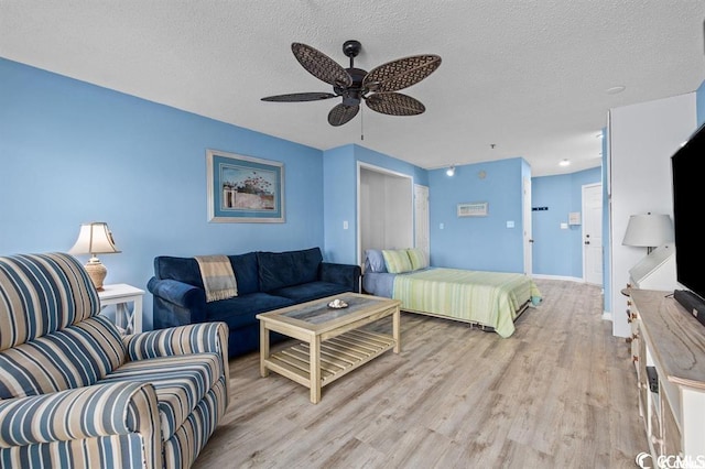 bedroom featuring ceiling fan, a textured ceiling, and light wood-type flooring