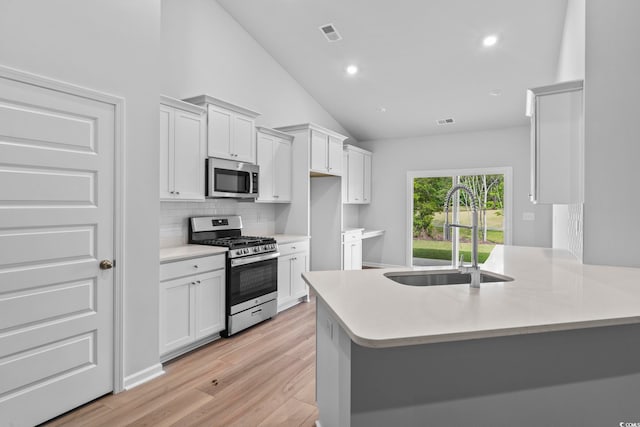 9746 Indigo Creek Blvd, Murrells Inlet, SC 29576 - kitchen featuring stainless steel appliances, a sink, decorative backsplash, vaulted ceiling, and light countertops