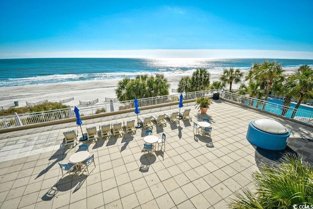 view of patio featuring a beach view and a water view