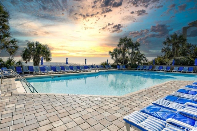 pool at dusk featuring a patio area