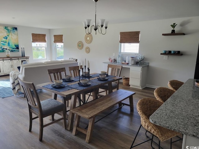 dining area featuring dark wood-type flooring, a notable chandelier, and plenty of natural light