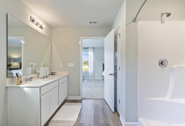 bathroom featuring a shower, vanity, and hardwood / wood-style floors