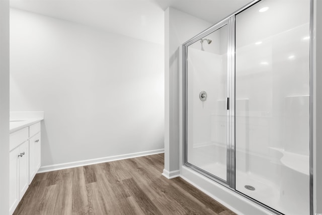 bathroom featuring vanity, wood-type flooring, and a shower with shower door