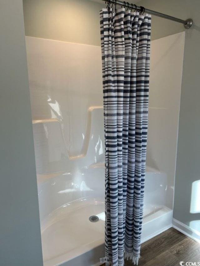 bathroom featuring walk in shower and hardwood / wood-style flooring