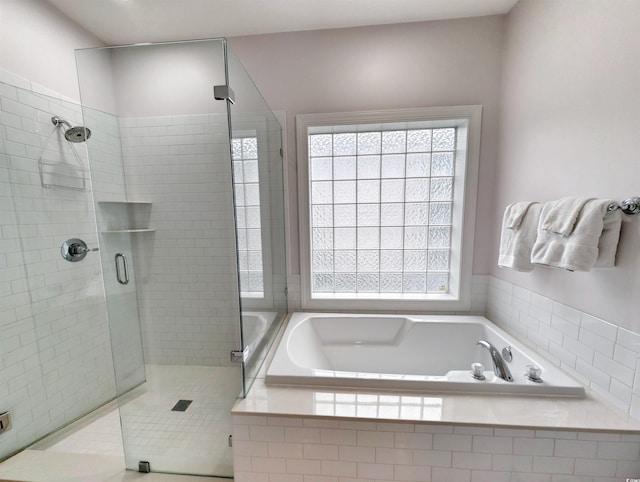 bathroom featuring shower with separate bathtub and a healthy amount of sunlight