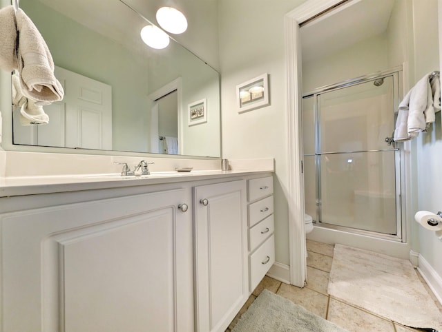 bathroom with tile patterned flooring, vanity, toilet, and an enclosed shower