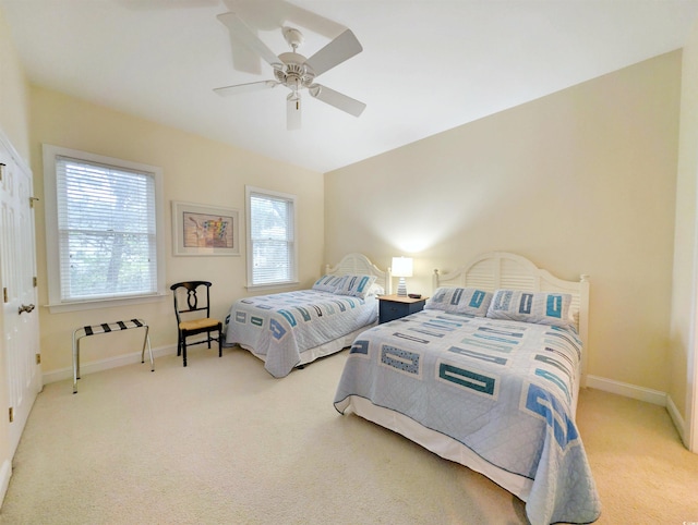 carpeted bedroom featuring ceiling fan and multiple windows