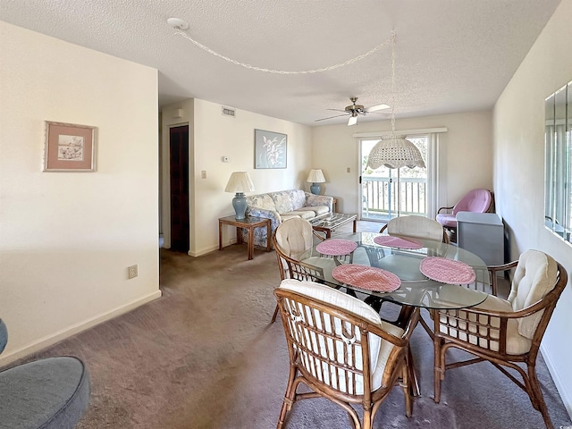 carpeted dining room featuring ceiling fan and a textured ceiling