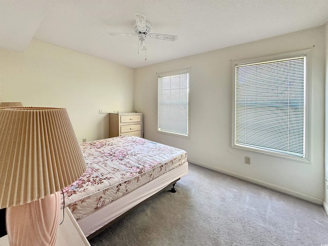 carpeted bedroom featuring a textured ceiling and ceiling fan