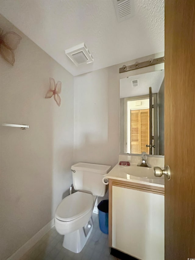 bathroom featuring vanity, wood-type flooring, a textured ceiling, and toilet