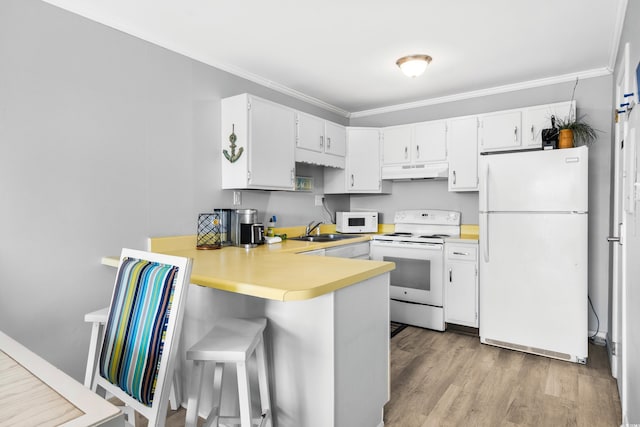 kitchen featuring kitchen peninsula, light wood-type flooring, ornamental molding, white appliances, and white cabinets