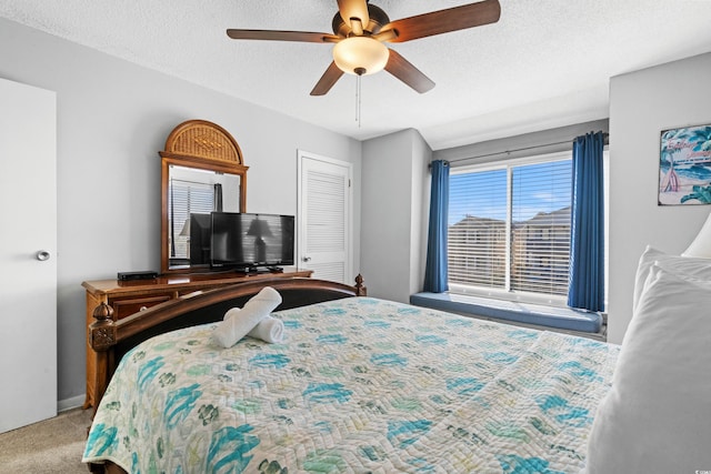 carpeted bedroom featuring ceiling fan, a closet, and a textured ceiling