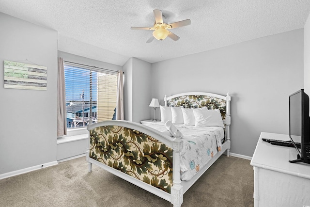 bedroom with ceiling fan, carpet floors, and a textured ceiling