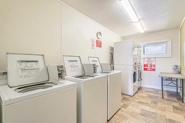 clothes washing area with washing machine and dryer, stacked washer and dryer, and a textured ceiling