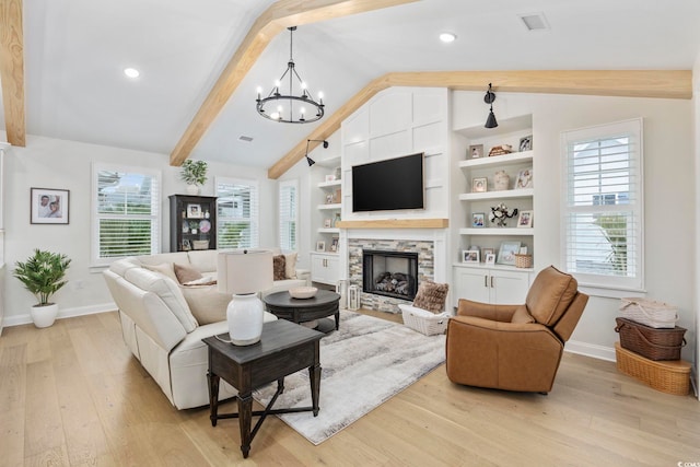 living room with vaulted ceiling with beams, a fireplace, a chandelier, and light hardwood / wood-style flooring