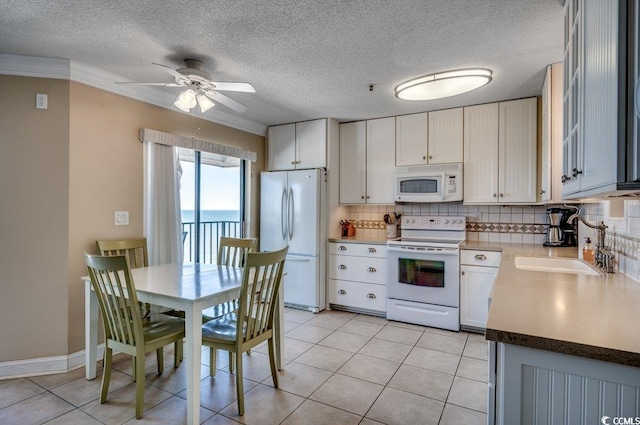 kitchen featuring tasteful backsplash, white appliances, sink, and white cabinets