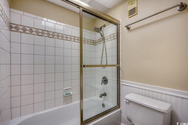 bathroom featuring bath / shower combo with glass door and toilet