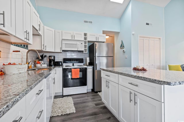 kitchen featuring white appliances, white cabinets, sink, light stone countertops, and dark hardwood / wood-style flooring