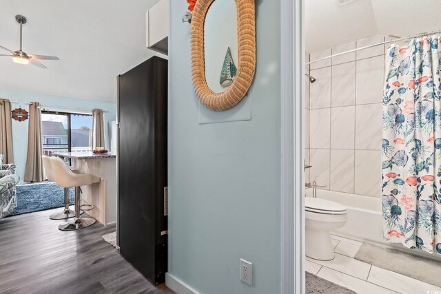 bathroom with shower / bath combo, ceiling fan, hardwood / wood-style flooring, toilet, and lofted ceiling