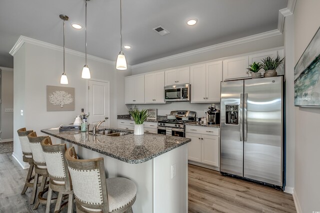 kitchen with white cabinetry, sink, stainless steel appliances, light hardwood / wood-style flooring, and decorative light fixtures