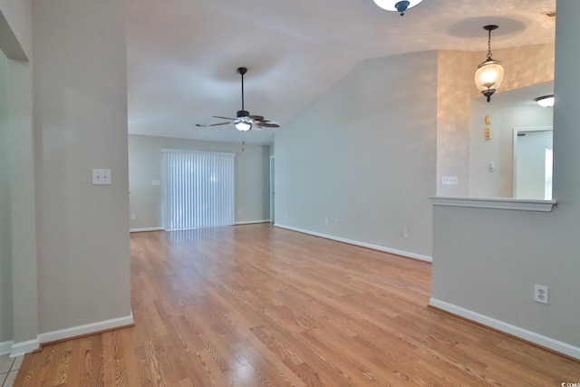 empty room featuring ceiling fan, light wood-type flooring, and vaulted ceiling