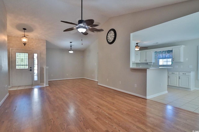 entryway featuring lofted ceiling, ceiling fan, and light hardwood / wood-style flooring