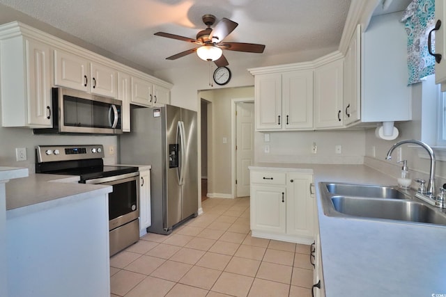 kitchen featuring light tile patterned floors, sink, stainless steel appliances, and white cabinetry