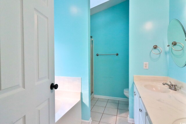 bathroom with tile patterned floors, toilet, vanity, and a washtub