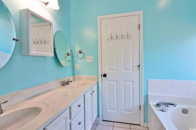 bathroom with a bathing tub, vanity, and tile patterned floors