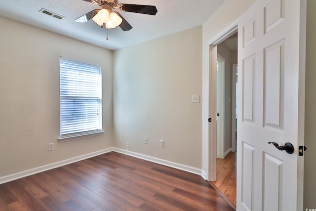 spare room featuring a textured ceiling, ceiling fan, and dark hardwood / wood-style floors