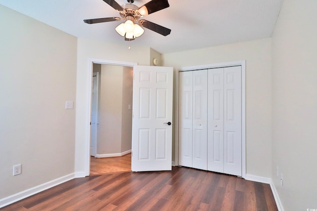 unfurnished bedroom with a closet, dark hardwood / wood-style floors, and ceiling fan