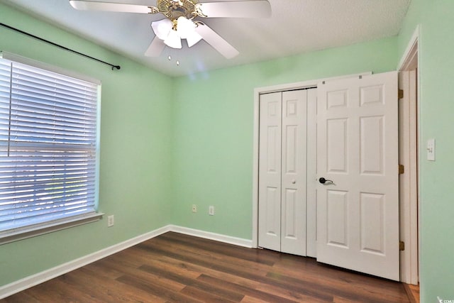 unfurnished bedroom with a closet, dark hardwood / wood-style floors, and ceiling fan