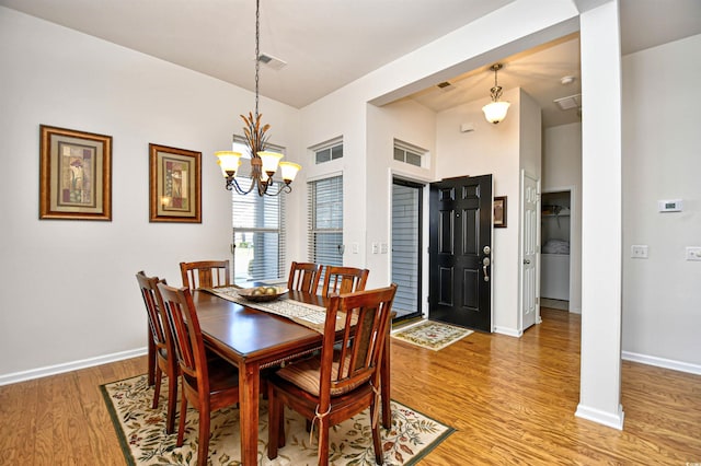 dining space with hardwood / wood-style flooring and a chandelier