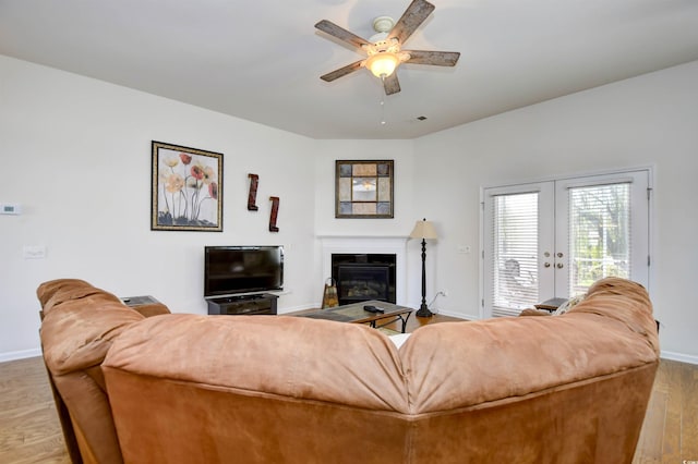 living room with french doors, light hardwood / wood-style floors, and ceiling fan