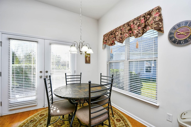 dining area with hardwood / wood-style floors, a notable chandelier, and a healthy amount of sunlight