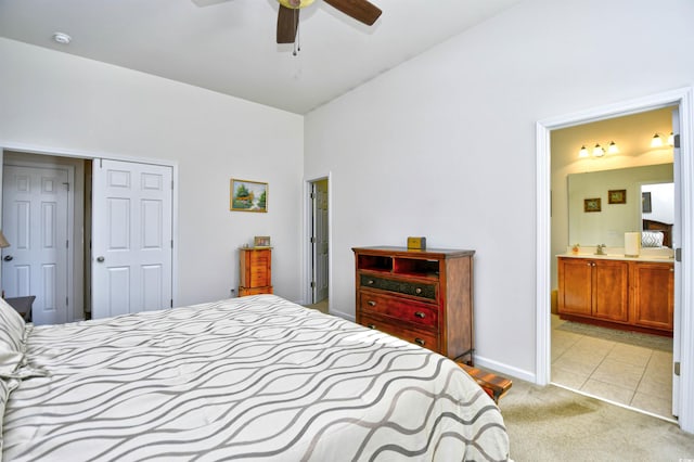 bedroom featuring ensuite bath, vaulted ceiling, sink, light colored carpet, and ceiling fan