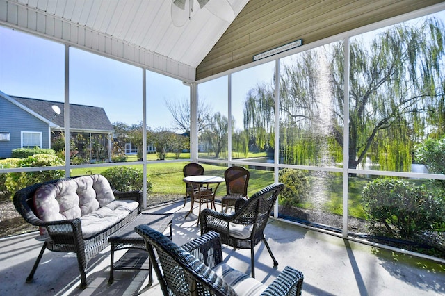 sunroom featuring vaulted ceiling and ceiling fan