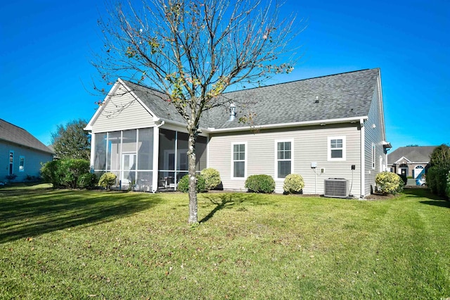 back of property with a lawn, a sunroom, and central AC