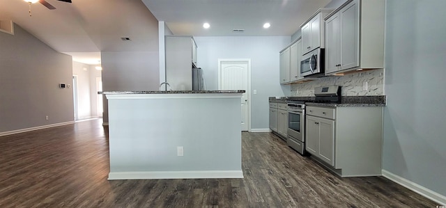 kitchen featuring stainless steel appliances, gray cabinets, dark hardwood / wood-style flooring, decorative backsplash, and ceiling fan