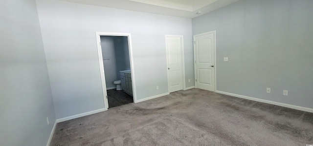 unfurnished bedroom with ensuite bathroom and light colored carpet