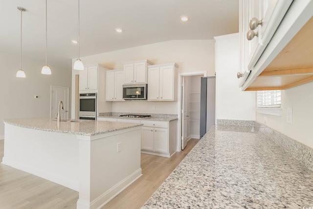 kitchen with white cabinetry, hanging light fixtures, light wood-type flooring, appliances with stainless steel finishes, and light stone countertops