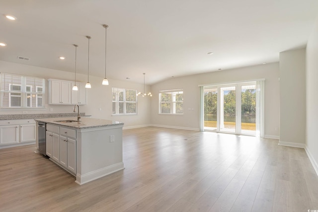 kitchen featuring sink, white cabinetry, a center island with sink, light hardwood / wood-style flooring, and pendant lighting