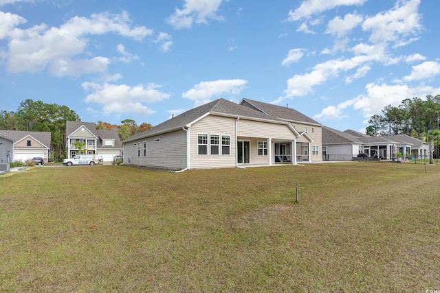 rear view of property featuring a lawn and central air condition unit